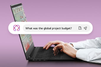 This image shows hands typing on a laptop with a search bar displaying the question, 'What was the global project budget?'