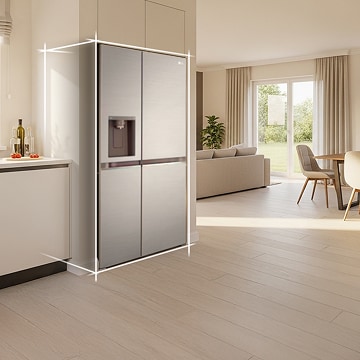 Bright beige-toned kitchen interior with a silver LG fridge freezer built into the left side. On the right, a dining table with flowers placed on top completes the scene.