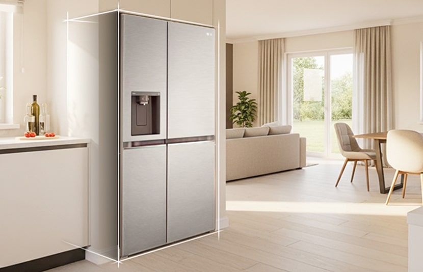 Bright beige-toned kitchen interior with a silver LG fridge freezer built into the left side. On the right, a dining table with flowers placed on top completes the scene.