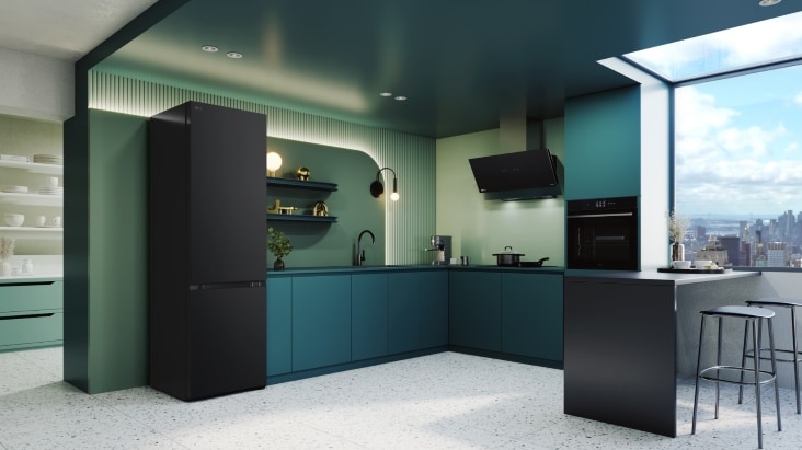 LG bottom freezer fridge in a stylish teal and black kitchen with open shelving and city view window, showcasing modern design and compact efficiency.
