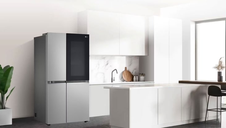 LG InstaView fridge freezer in a bright, minimalist white kitchen with marble backsplash and island counter, blending modern design with smart storage.
