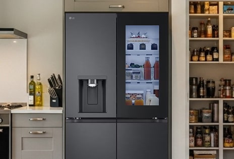 LG multi-door fridge freezer in matte black with InstaView panel, perfectly fitted into a modern pantry-style kitchen with wooden shelf accents.