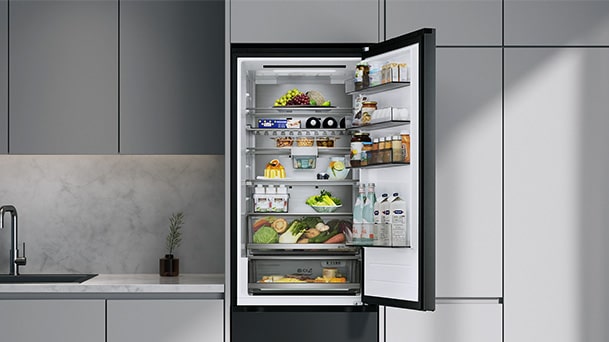A neatly organized single-door LG refrigerator filled with fresh food and beverages in a modern kitchen