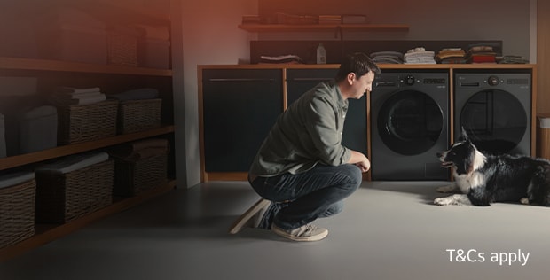 A man and his dog in front of an LG washing machine and tumble dryer