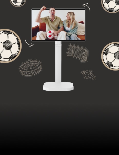 On the screen of the LG Smart Monitor Swing, a couple is seen on the sofa; the man is holding a plush soccer ball and cheering with a raised fist, while the woman smiles next to him.