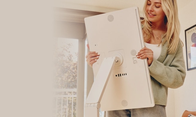 A woman rotating an LG Smart Monitor screen.