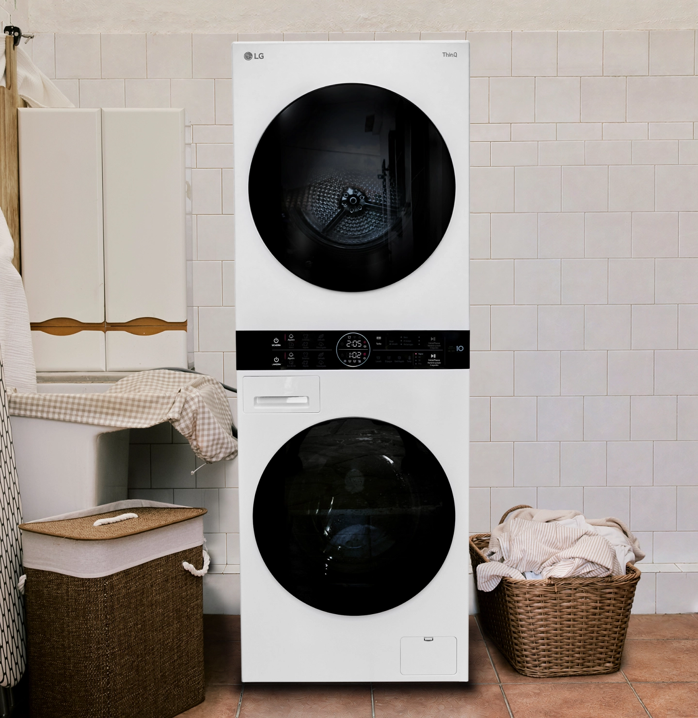 A close-up view of a white stacked LG WashTower unit, in a tiled utility room next to a wicker laundry basket.