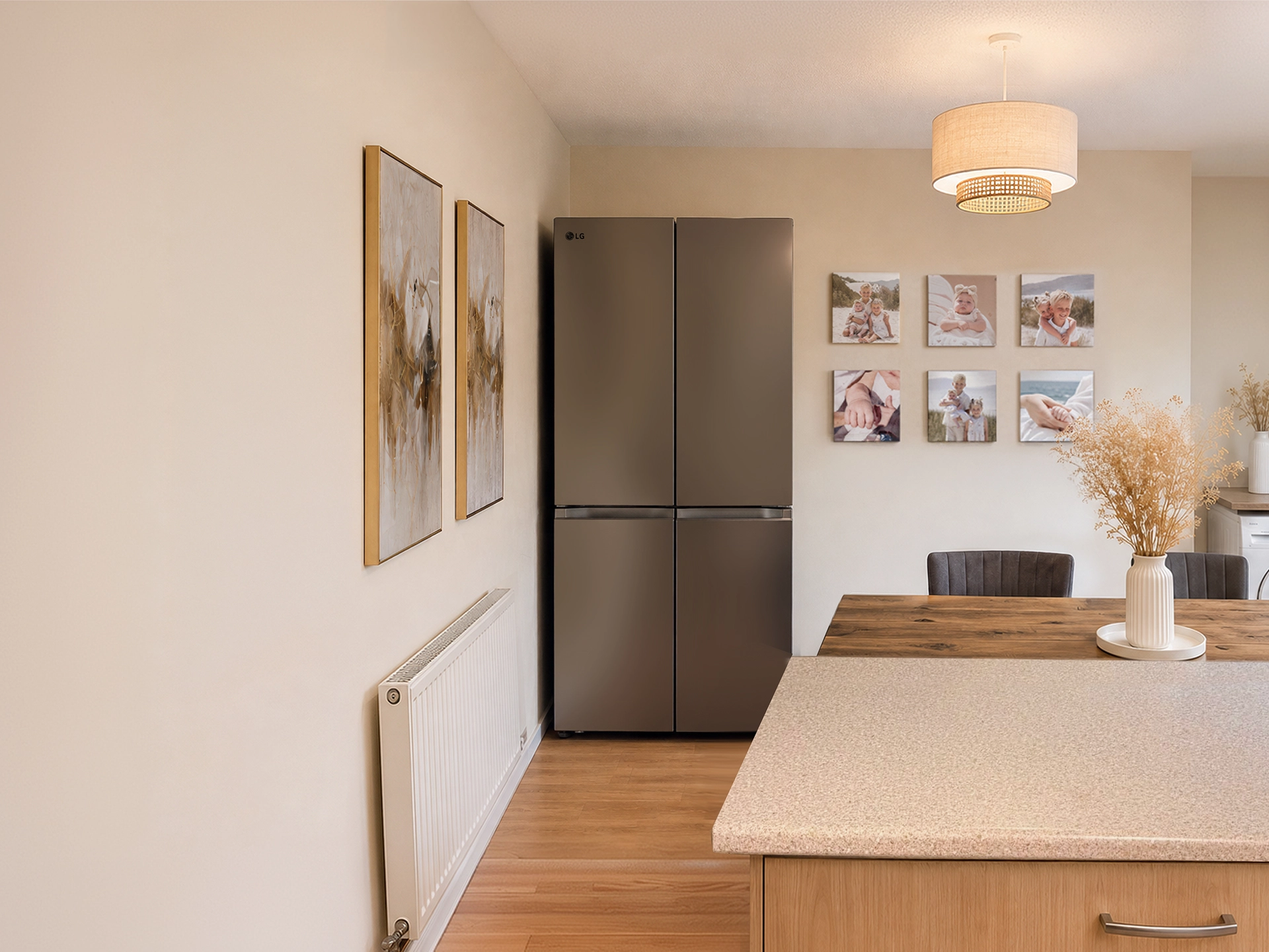 A stainless steel LG multi-door fridge freezer stands in a warm, modern dining room next to a wooden table and wall art.