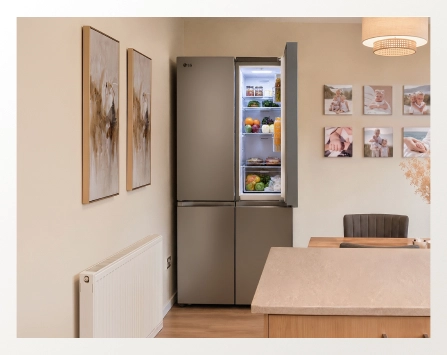 An open LG refrigerator shown from a wide view in a modern dining room.