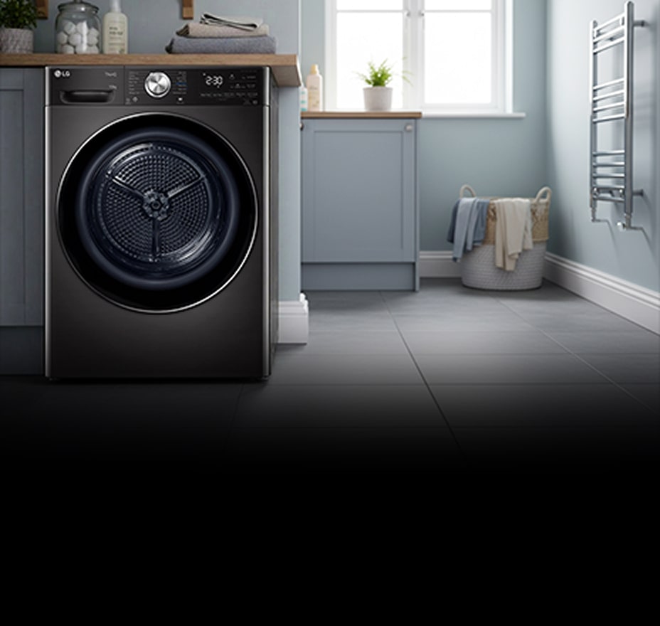 A white front-loading washing machine is installed in a bright laundry room with pastel cabinetry and a window.