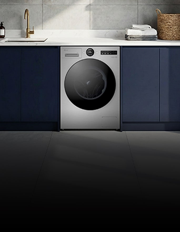 A white front-loading washer sits beneath a wooden shelf, surrounded by neatly placed towels and decor.