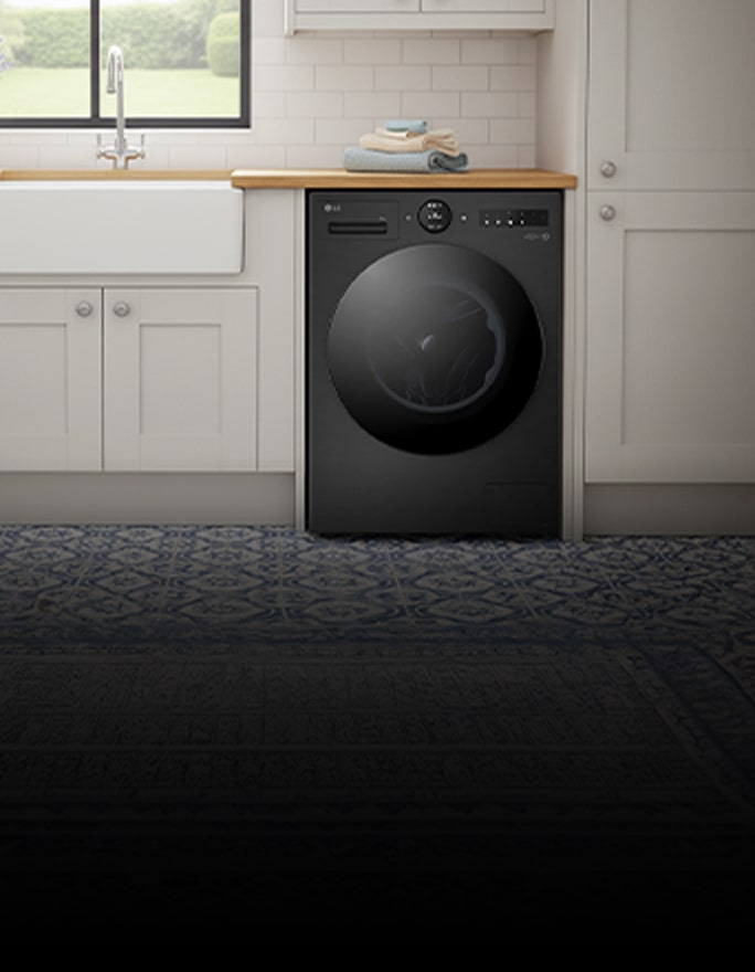 A white front-loading washing machine is placed between white-toned cabinets.