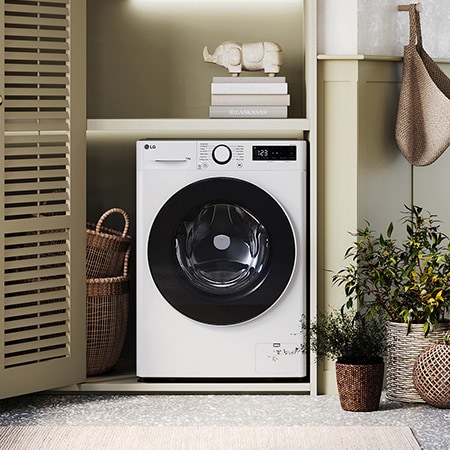 The white LG 13kg washing machine F4Y513WWLN1, featuring a distinctive black porthole ring, shown installed in a stylish, modern laundry closet.