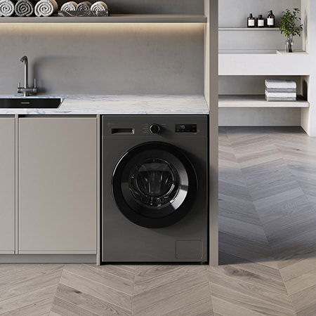 The LG 9kg washing machine F4X1009NMK in Dark Stone, shown built-under a counter in a modern laundry room.