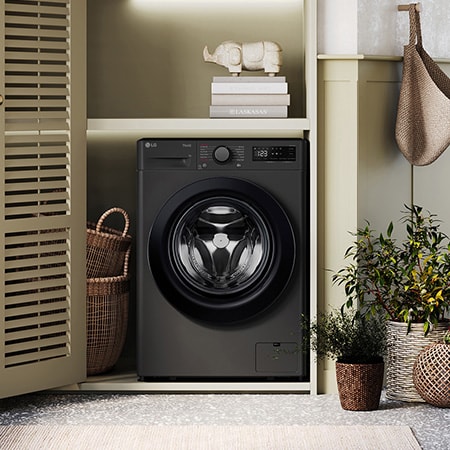 The LG 10kg/6kg washer-dryer FWY706GBTN1 in Slate Grey, shown installed in a stylish, modern laundry closet.