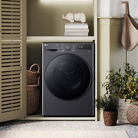 The LG 9kg dryer FDV709GN in Slate Grey, shown installed in a stylish, modern laundry closet.