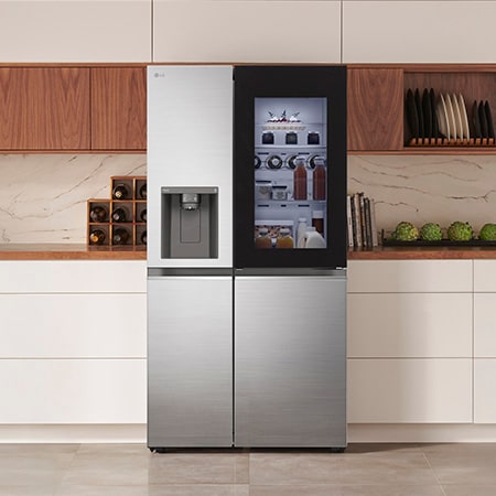 LG Side-by-Side Refrigerator GSXV80PZLE in a stainless steel finish, featuring InstaView™ Door-in-Door® and a dispenser, seamlessly integrated into a modern kitchen with white and wood cabinets.