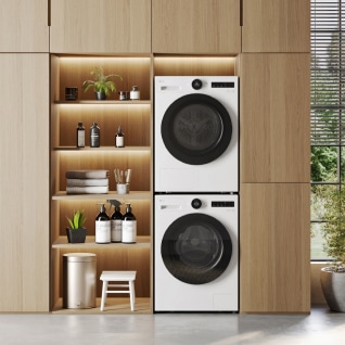 In the laundry room, a white LG washing machine and dryer are stacked on top of each other, with various books and plants arranged to the left.