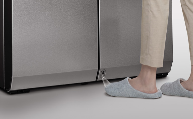 A left foot is approached to the auto open door sensor of LG SIGNATURE Refrigerator.