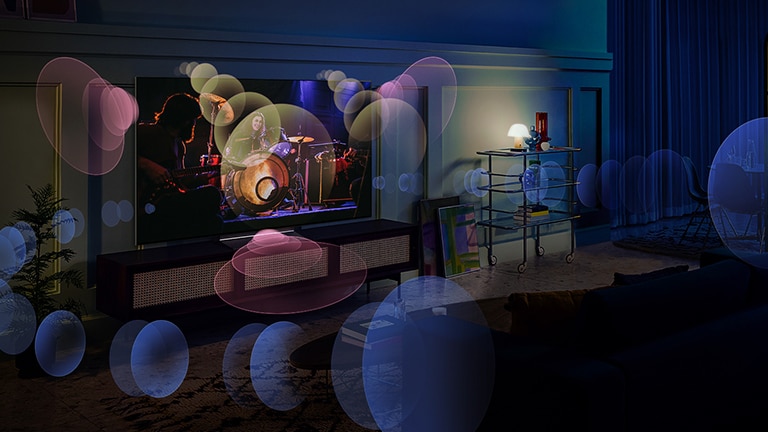 A woman sits on a couch watching a concert with bubbles depicting surround sound around her. 