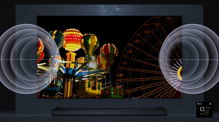 A TV screen shows a very bright Ferris wheel in night and there is a visual effect of sound on left and right side of a TV. 