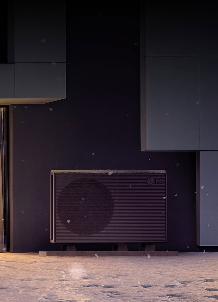There is a LG THERMA V in front of a house with shining yellow lights. The snow piled up on the products and the ground.