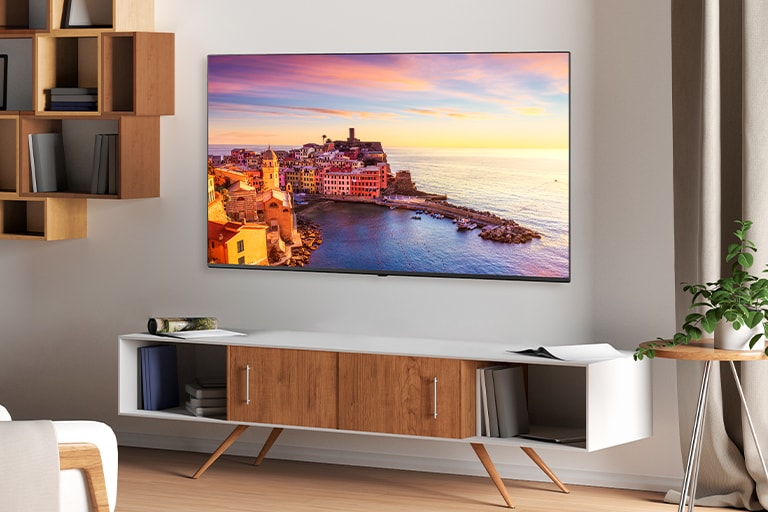 A TV is hanging on the wall of the hotel room, and the TV screen is bright and clear.