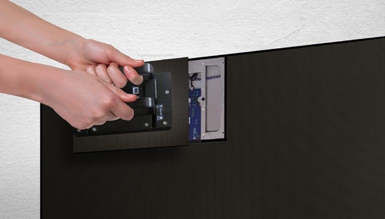 A person replaces one of the LED modules from the front by using the magnetic tool provided.