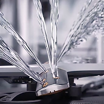 Intense water streams from dishwasher blades in close-up.	