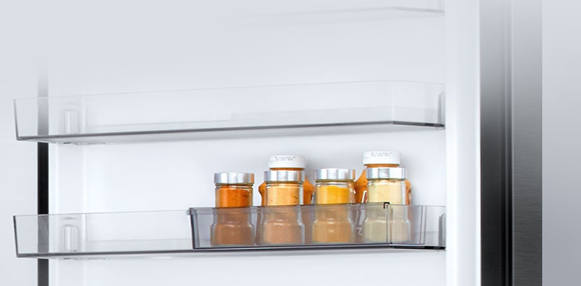 LG bottom freezer (GBBS524CPY) interior with transparent sliding mini door basket holding six small sauce bottles