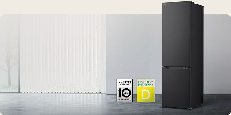 LG bottom freezer matte black front view in bright room with vertical blinds with 10 year compressor warranty and Energy Efficiency A icons below