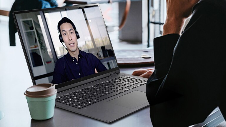 It shows a scene that a man has a video conference in the café.