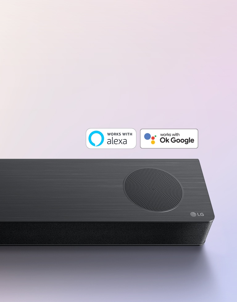 LG Sound Bar is place on the ground, showing LG logo right corner of the sound bar. Alexa logo and OK GOOGLE logos are placed on the sound bar.
