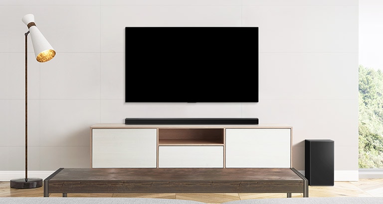 A TV and a soundbar placed in a plain living room.