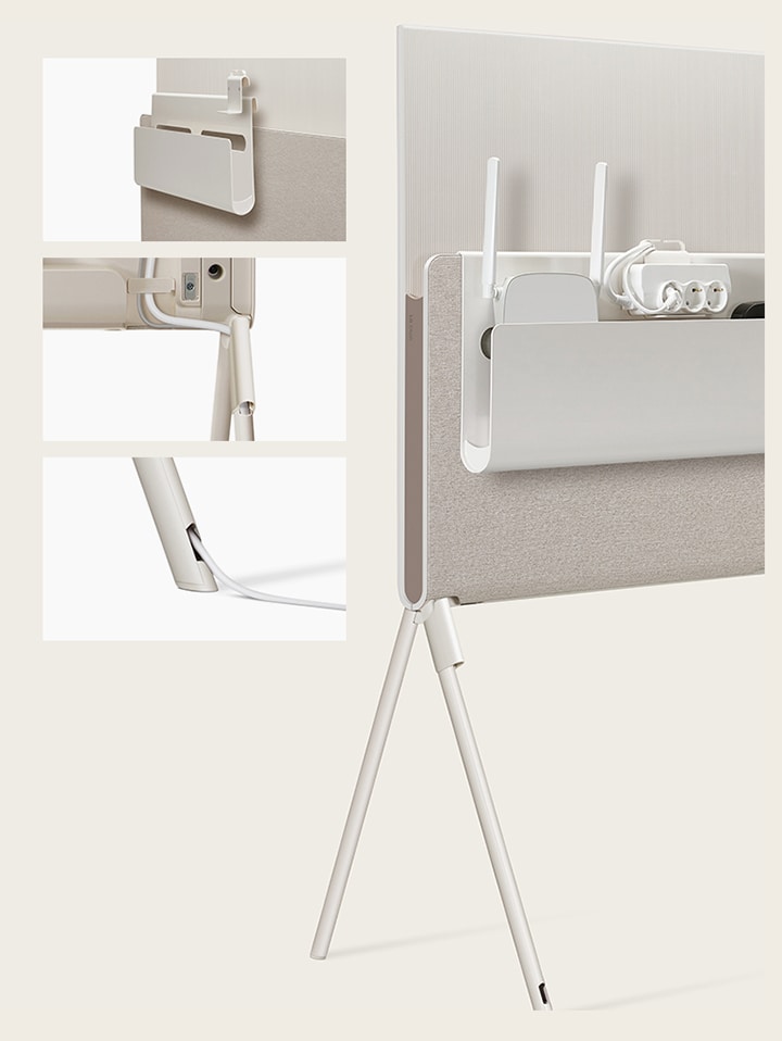 LG OLED Posé’s Cable & Accessory Organiser hangs from the Media Shelf.   LG OLED Posé’s detachable cable holder is seen closeup on the base of the TV.   LG OLED Posé’s cable is seen closeup running out of the TV leg.   LG OLED Posé is seen from the back with the Cable & Accessory Organiser holding a router, outlet, and device.