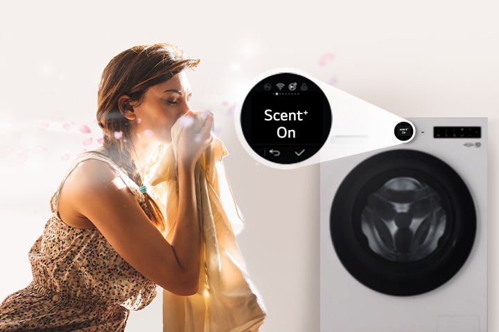 A woman is sitting in front of a washing machine, sniffing the scent of washed clothes.	