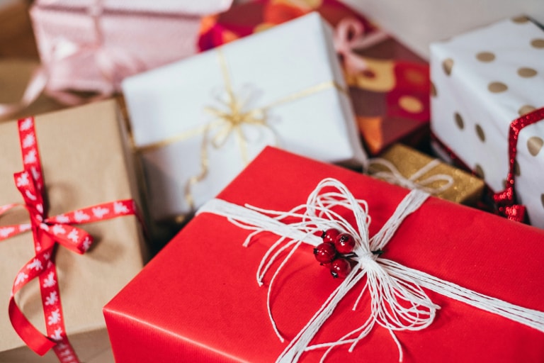 A collection of elegantly wrapped gifts, encapsulating the essence of luxury tech gifting and the sophistication of high-end gadgets for the discerning gentleman.