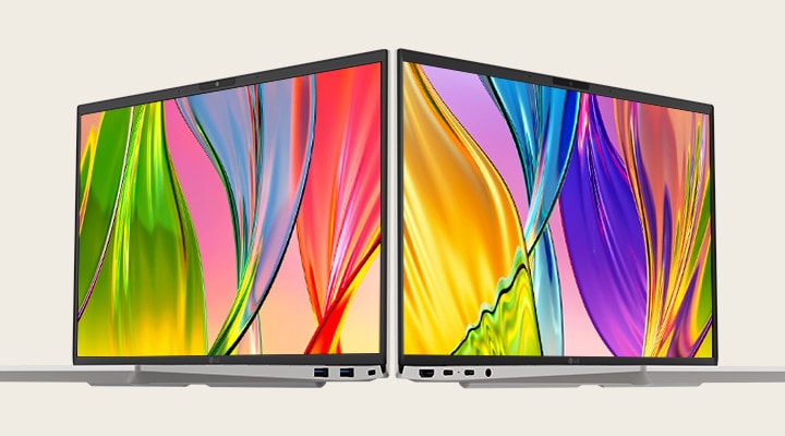 The image features two laptops placed back-to-back, showcasing vibrant, colorful screens with thin bezels, emphasizing vivid visuals and sleek design.
