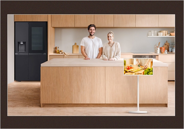 Image of a neat kitchen and a couple looking straight ahead with happy smiles