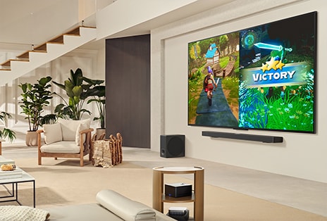 Family of 3 playing a game in a living room with a LG TV mounted on a wall above a LG Soundbar. Zero Connect Box sits inside a coffee table.