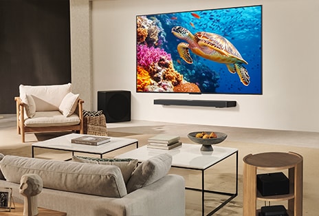 A family sits on a couch facing a LG TV mounted on a wall above a LG Soundbar. Zero Connect Box sits inside a coffee table.