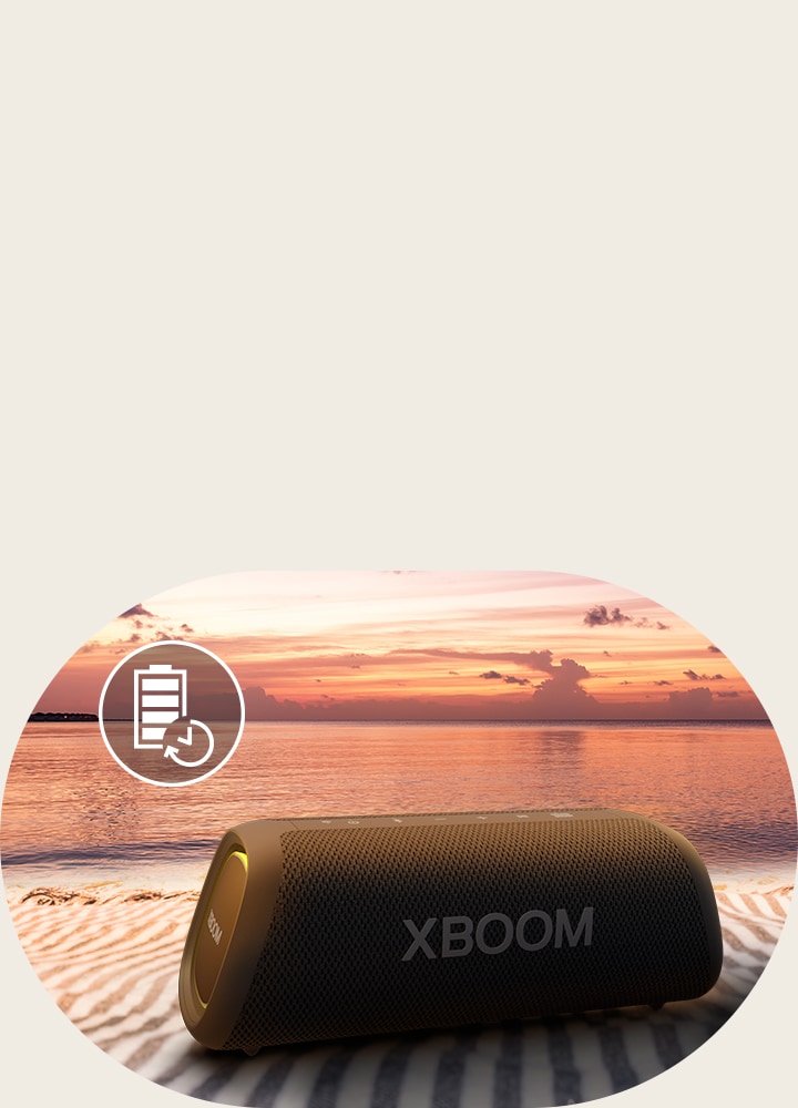 The speaker is placed on a beach towel. In front of the speaker, it shows sunset beach to illustrate that this speaker can be played up to 18 hours.