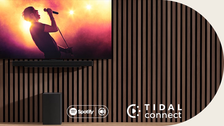 LG OLED C is placed on the wall, below LG Soundbar  SC9S is placed through an exclusive bracket. Subwoofer is placed underneath. TV shows a concerts scene.