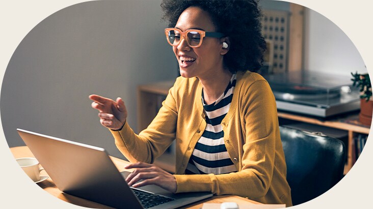 A woman wearing white earbud is speaking with her fingers pointing forward, using the earbud's call feature.