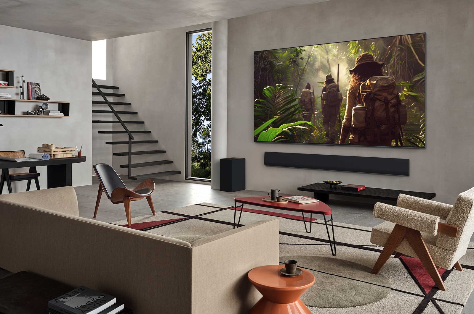 Wide view of a living room inside a premium home, a man is watching a movie on his wall-mounted LG OLED TV. The TV's design blends elegantly with the wall and the interior design.