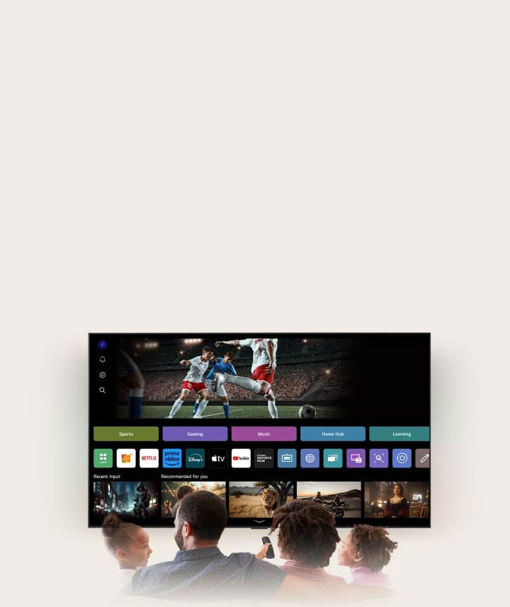 Một gia đình bốn người quây quần bên TV LG AI. Một vòng tròn xuất hiện quanh người cầm điều khiển, hiển thị tên của họ - minh họa cách AI Voice ID nhận diện giọng nói riêng biệt của từng thành viên. Giao diện webOS sau đó tự động chuyển đổi tài khoản và đề xuất nội dung phù hợp với sở thích cá nhân.