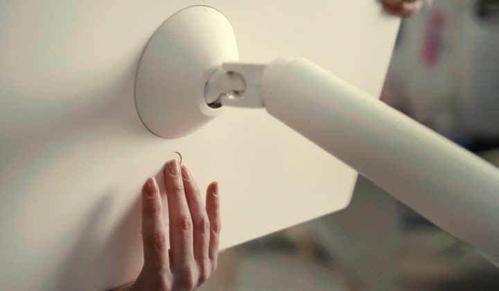 Cận cảnh màn hình StanbyME 2 được tháo rời, chuyển cảnh sang người mẫu đang mang thiết bị với vỏ bọc folio và dây đeo.