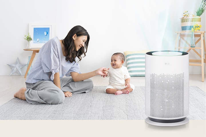 Mẹ và bé đang có khoảng thời gian vui vẻ trong phòng khách. Không khí trong lành đang lan tỏa từ máy lọc không khí bên phải.