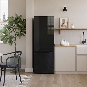 Tủ lạnh ngăn đá dưới LG 335L B33BG màu Black Glass đặt trong căn bếp sáng sủa bên cạnh tủ bếp màu trắng.