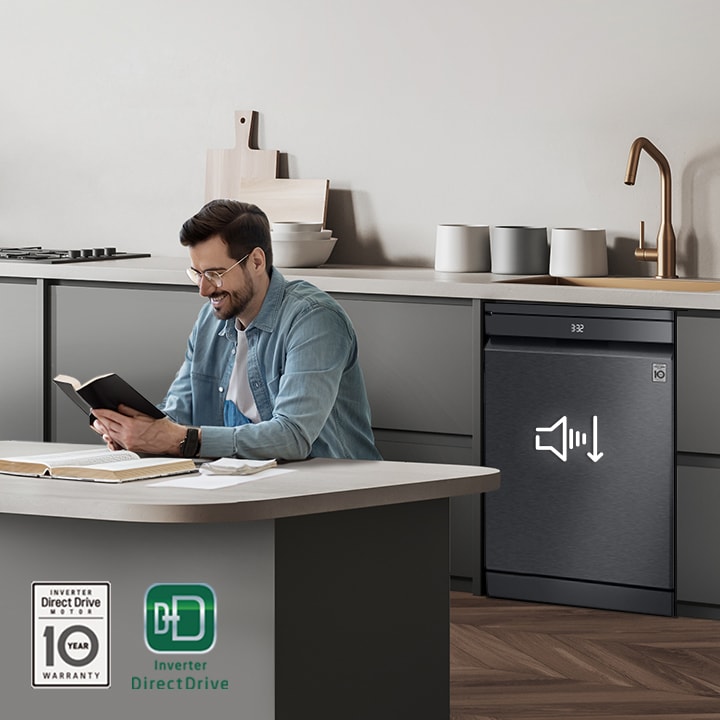 Người đàn ông đọc sách tại bàn đảo bếp trong khi máy rửa bát độc lập LG đang hoạt động ở phía sau.